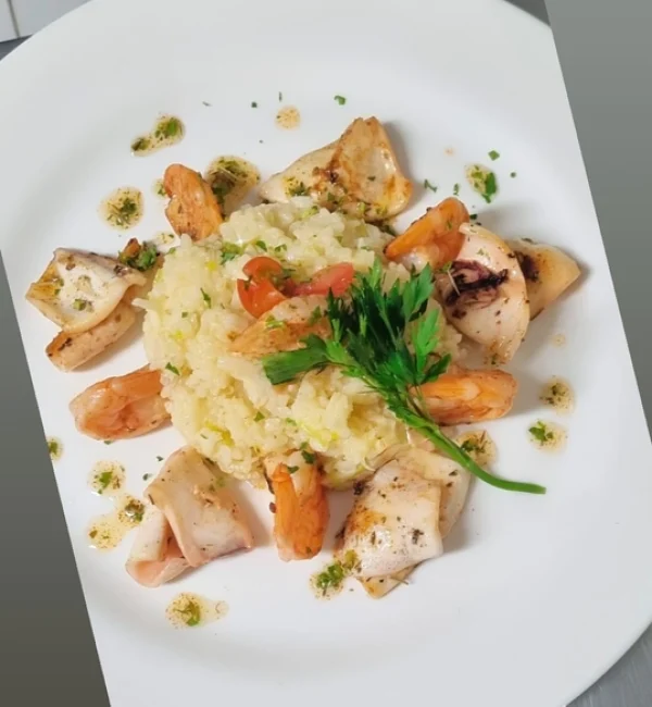 Camarão salteados em vinho branco aromatizado com ervas finas servido com risoto de alho poró e lulas salteadas em molho pesto.(1)redimensionada