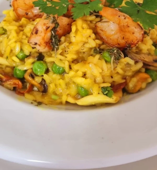 Risoto Al Mare, Camarão e lulas salteados em açafrão, servido com arroz arborio, ervilhas frescas aromatizado com azeite de ervas .redimensionada